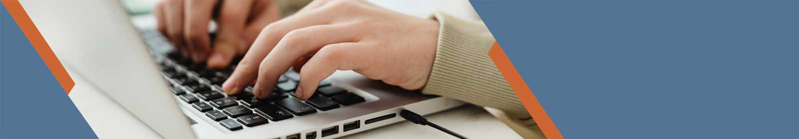 Hands typing on a laptop keyboard